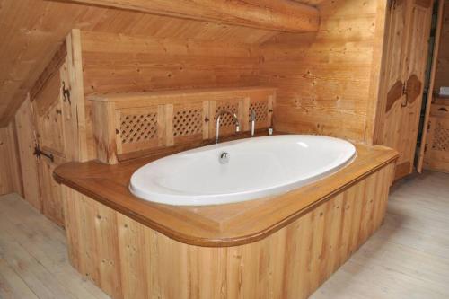 - une salle de bains pourvue d'une baignoire dans une cabine en bois dans l'établissement Les Gentianes Appartement 5 personnes à 50 mètres des pistes Meribel 3 vallées, à Méribel