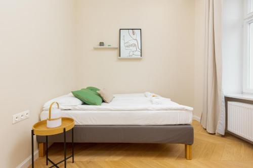łóżko w białym pokoju ze stołem w obiekcie Apartments Warsaw Targowa by Noclegi Renters w Warszawie