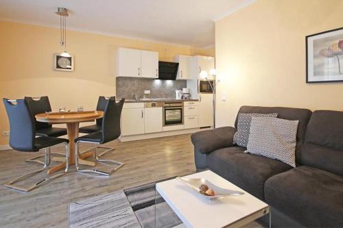 キュールングスボルンにあるHaus-Atlantik-Wohnung-1-06-110のリビングルーム(ソファ、テーブル付)、キッチンが備わります。