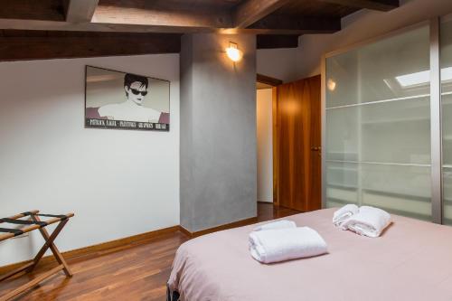 una camera da letto con un letto e due asciugamani di La Mansarda di Giulietta a Verona
