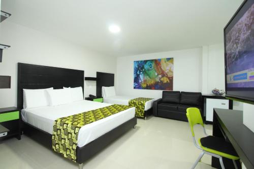 a hotel room with a bed and a flat screen tv at Hotel Genova Prado in Barranquilla