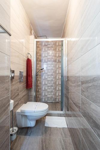 a bathroom with a toilet and a glass shower at Hotel Romantik Eger in Eger