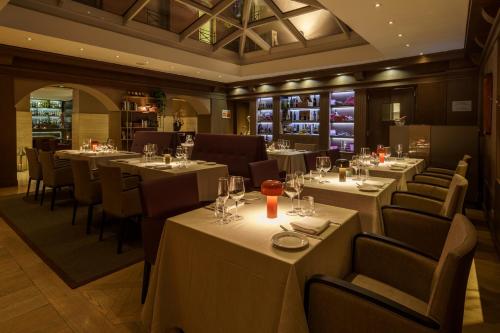 a restaurant with white tables and chairs with wine glasses at Hotel Indigo Rome - St. George by IHG in Rome