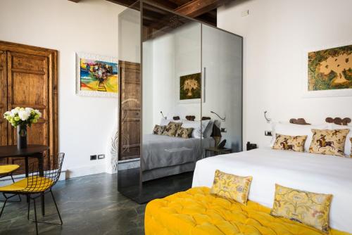 a bedroom with a large white bed and a yellow couch at Palazzo Delle Pietre - Luxury Apartments in Rome