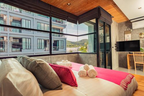 a bedroom with a large bed with towels on it at Cozy design studio near Nai Harn beach in Nai Harn Beach