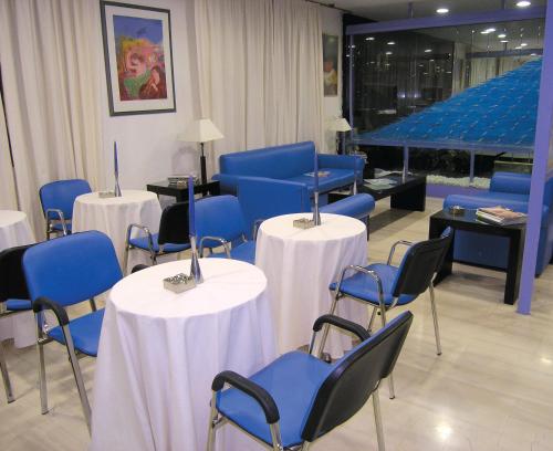 poczekalnia z niebieskimi krzesłami i stołami w budynku w obiekcie ROY Hotel w Atenach