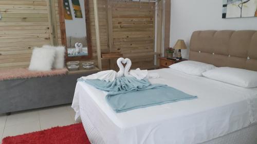 a bedroom with a bed with two swans on it at Estúdio conceito aberto - 3 pessoas in Araranguá