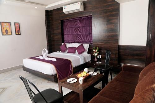 a hotel room with a bed and a table at Hotel Planet Four in Lonavala