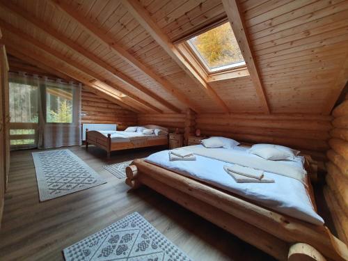 1 Schlafzimmer mit 2 Betten in einem Blockhaus in der Unterkunft Cabana Raisa in Valea Moldovei