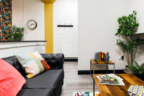 a living room with a black leather couch and a table at The DreamArt Warehouse in London