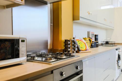 a kitchen with a stove top oven next to a microwave at The DreamArt Warehouse in London