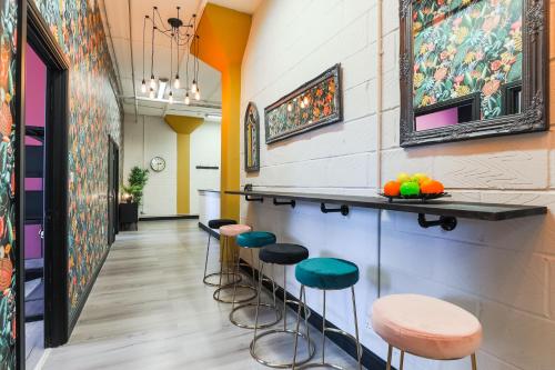 a bar with stools and paintings on the wall at The DreamArt Warehouse in London