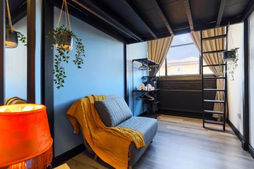 a living room with a chair and a ladder at The DreamArt Warehouse in London
