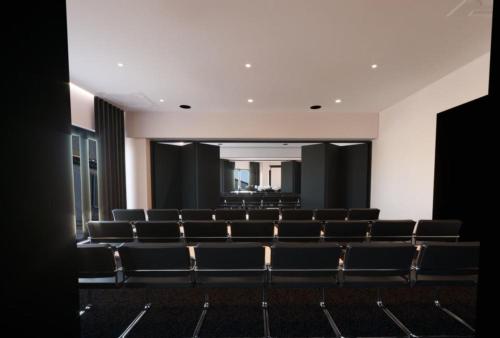 an empty auditorium with black chairs and a large mirror at Le Centell Hotel & Spa in Antananarivo