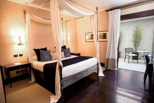 a bedroom with a bed with a canopy at Hotel Casa Higueras in Valparaíso