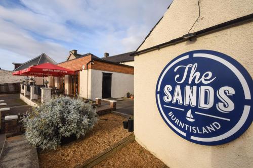 una señal para el restaurante de arena al lado de un edificio en Burntisland Sands Hotel, en Burntisland