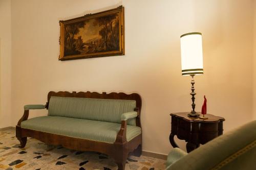 a chair in a room with a lamp and a painting at Palazzo Benucci - Residenza di Charme in Santa Maria Capua Vetere