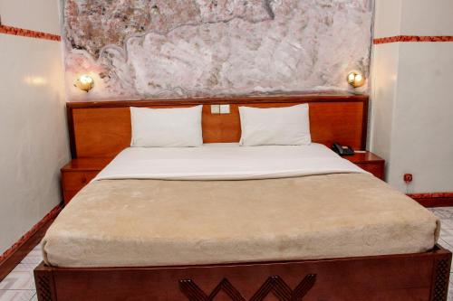 a bedroom with a large bed with a wooden headboard at Park hôtel in Lubumbashi