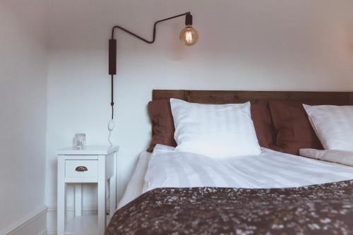 a bedroom with a bed with a lamp and a side table at Hotell Villa Borgen in Visby