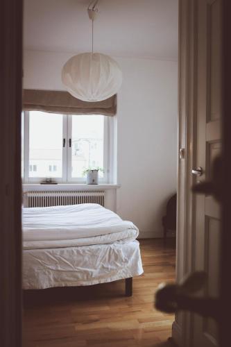 a white bedroom with a bed and a window at Hotell Villa Borgen in Visby