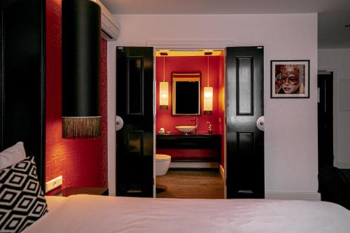 a bedroom with a bed and a bathroom with a sink at Le Theatre in Maastricht
