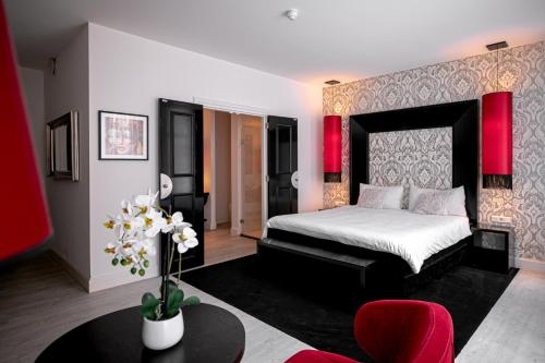 a bedroom with a bed and a table in a room at Le Theatre in Maastricht