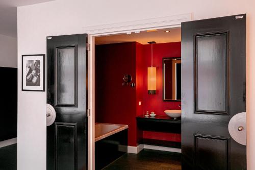 a bathroom with two sinks and a red wall at Le Theatre in Maastricht