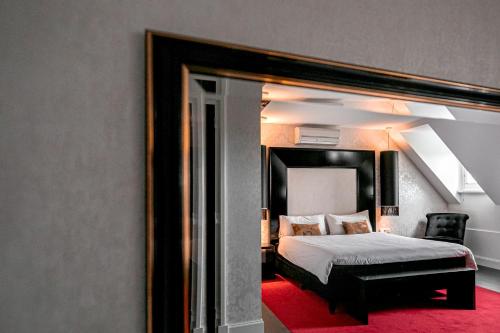 a bedroom with a bed and a large mirror at Le Theatre in Maastricht