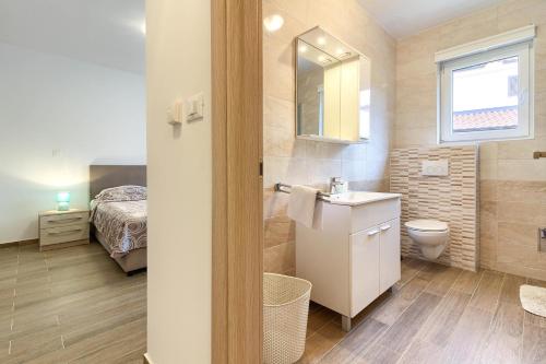 ein Badezimmer mit Waschbecken und Toilette und ein Bett in der Unterkunft Luxury villa Banjole with private pool 200m from the beach - WiiBuk in Banjole