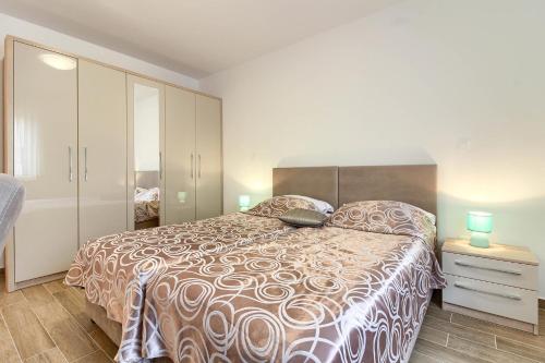 ein Schlafzimmer mit einem großen Bett mit einer braunen und weißen Bettdecke in der Unterkunft Luxury villa Banjole with private pool 200m from the beach - WiiBuk in Banjole