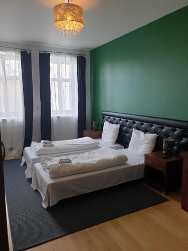 Apartamenty Rynek في ليزايسك: سريرين في غرفة بجدران خضراء