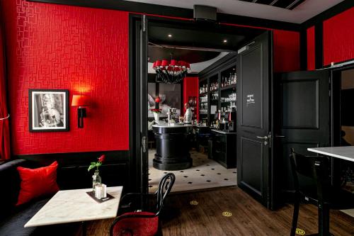 ein rotes Zimmer mit einer Bar mit einer roten Wand in der Unterkunft Le Theatre in Maastricht