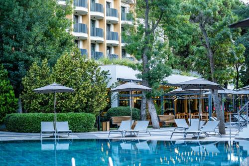 a hotel swimming pool with chairs and umbrellas at HVD Club Bor Ultra All Inclusive - Private Beach & Free parking in Sunny Beach