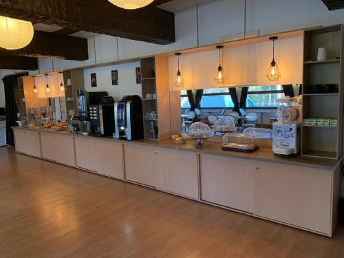 a restaurant with a long counter in a room at The Originals Boutique, Hôtel Lakeside, Biscarrosse , Lac in Parentis-en-Born