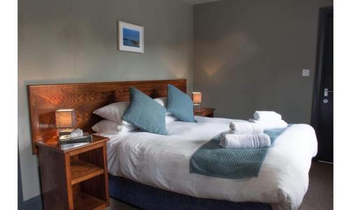 um quarto com uma cama grande e almofadas azuis em The Wellwood em Amble