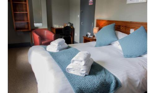 ein Hotelzimmer mit 2 Handtüchern auf einem Bett in der Unterkunft The Wellwood in Amble
