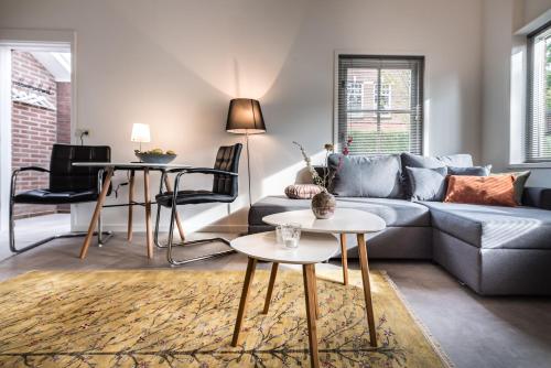 a living room with a couch and a table at Boutique Appartement-Hotel Villa Juttershof in Bergen