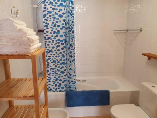 uma casa de banho com uma cortina de chuveiro azul e um WC. em BENITATXELL VISTAS IMPRESIONANTES em Benitachell