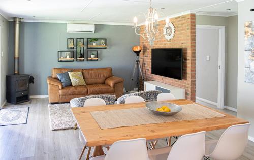 a living room with a table and chairs and a couch at Rest at Chabivin in Stellenbosch