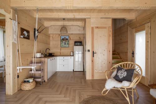 a kitchen with a refrigerator and a chair in a room at Stylowa Chata in Zakopane