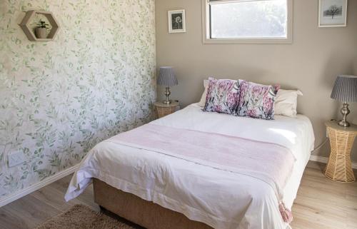 a bedroom with a bed with pink and white sheets at Rest at Chabivin in Stellenbosch