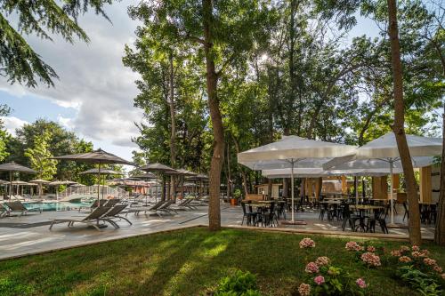 a patio with tables and chairs and umbrellas at HVD Club Bor Ultra All Inclusive - Private Beach & Free parking in Sunny Beach