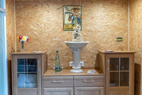 two dressers with a fountain in the middle of a room at Gaststätte und Pension Zur Einkehr in Neustadt