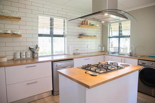 a kitchen with white cabinets and a stove top oven at Rest at Chabivin in Stellenbosch