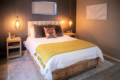 a bedroom with a large bed and two night stands at Rest at Chabivin in Stellenbosch