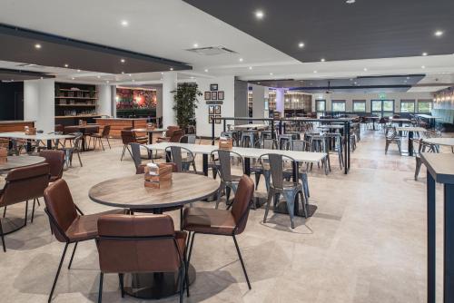 - un restaurant avec des tables et des chaises dans une salle dans l'établissement The Willows Training Centre, à Wyboston