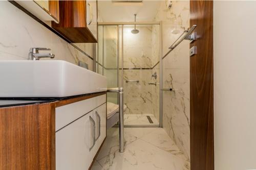La salle de bains est pourvue d'un lavabo et d'une douche. dans l'établissement TEMA LARA APART, à Antalya