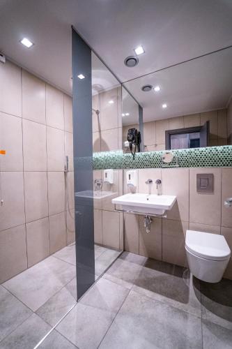 a bathroom with a sink and a toilet and a mirror at HVD Club Bor Ultra All Inclusive - Private Beach & Free parking in Sunny Beach