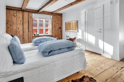 a bedroom with two beds with blue pillows at Boen Gård in Kristiansand