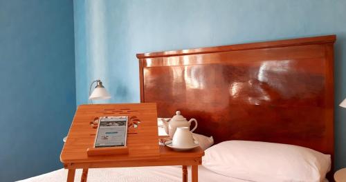 un tavolo in legno con un cellulare su un letto di Fabiola B & B a Marino